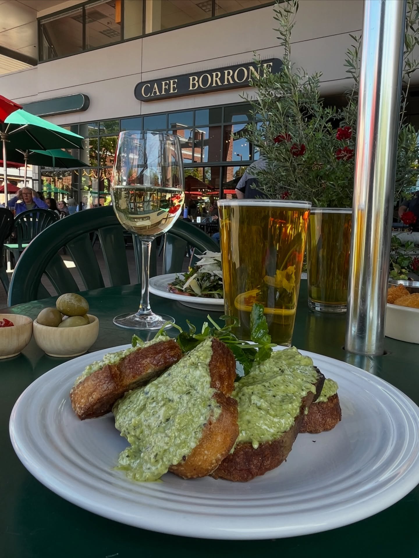 Pesto toast with a glass of wine and beer on the patio