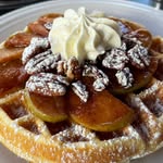 Waffle topped with whipped cream and pecans
