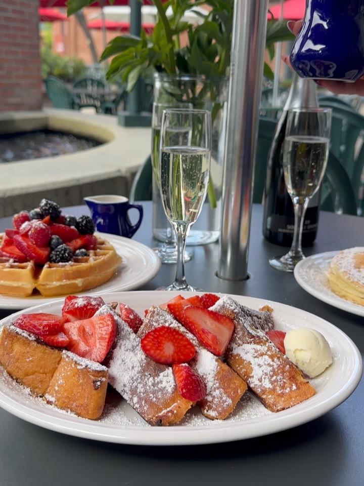 French toast, berry waffle and pancakes with champagne on the patio