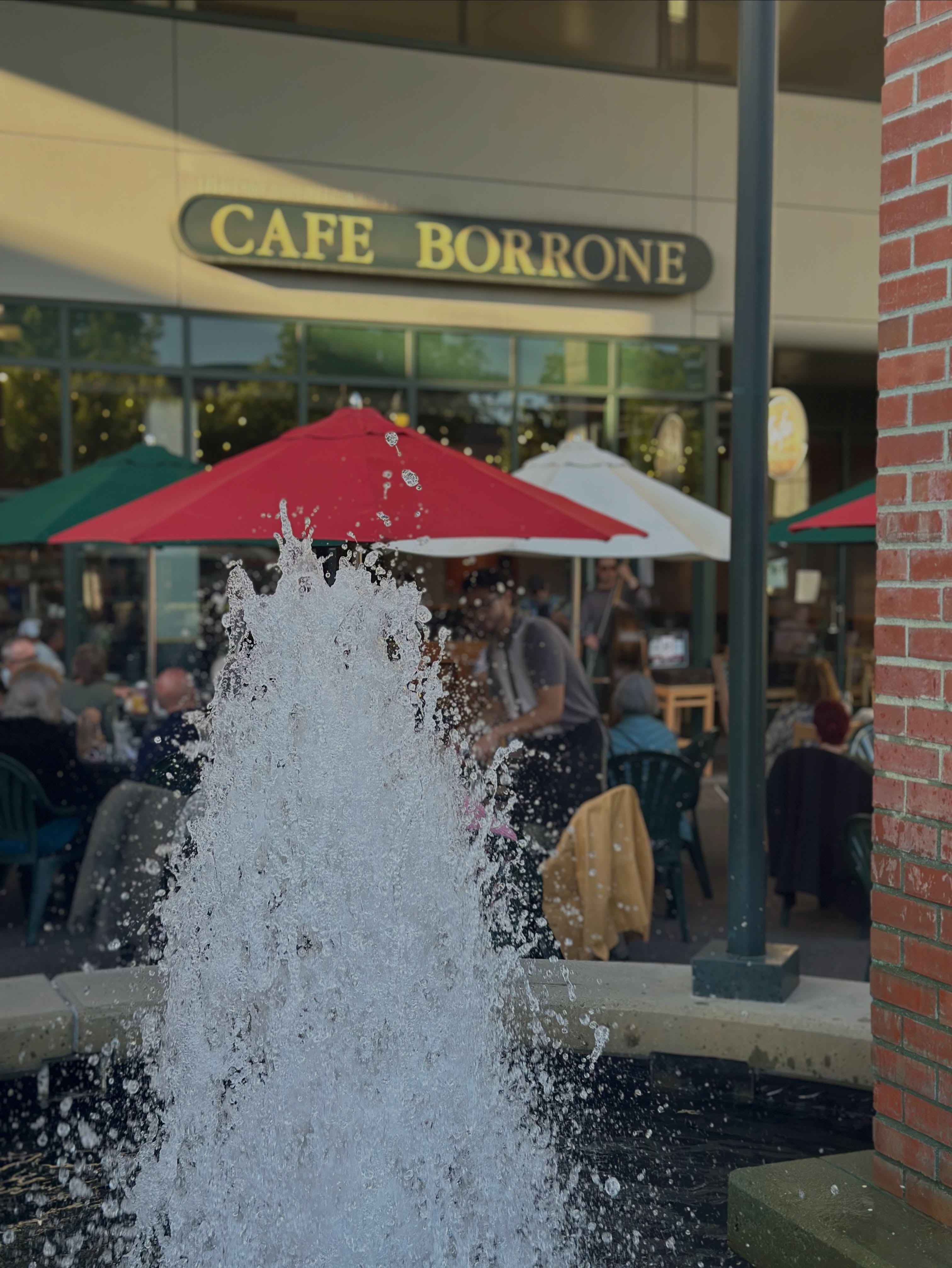 The plaza fountain splashing in front of the Cafe Borrone sign