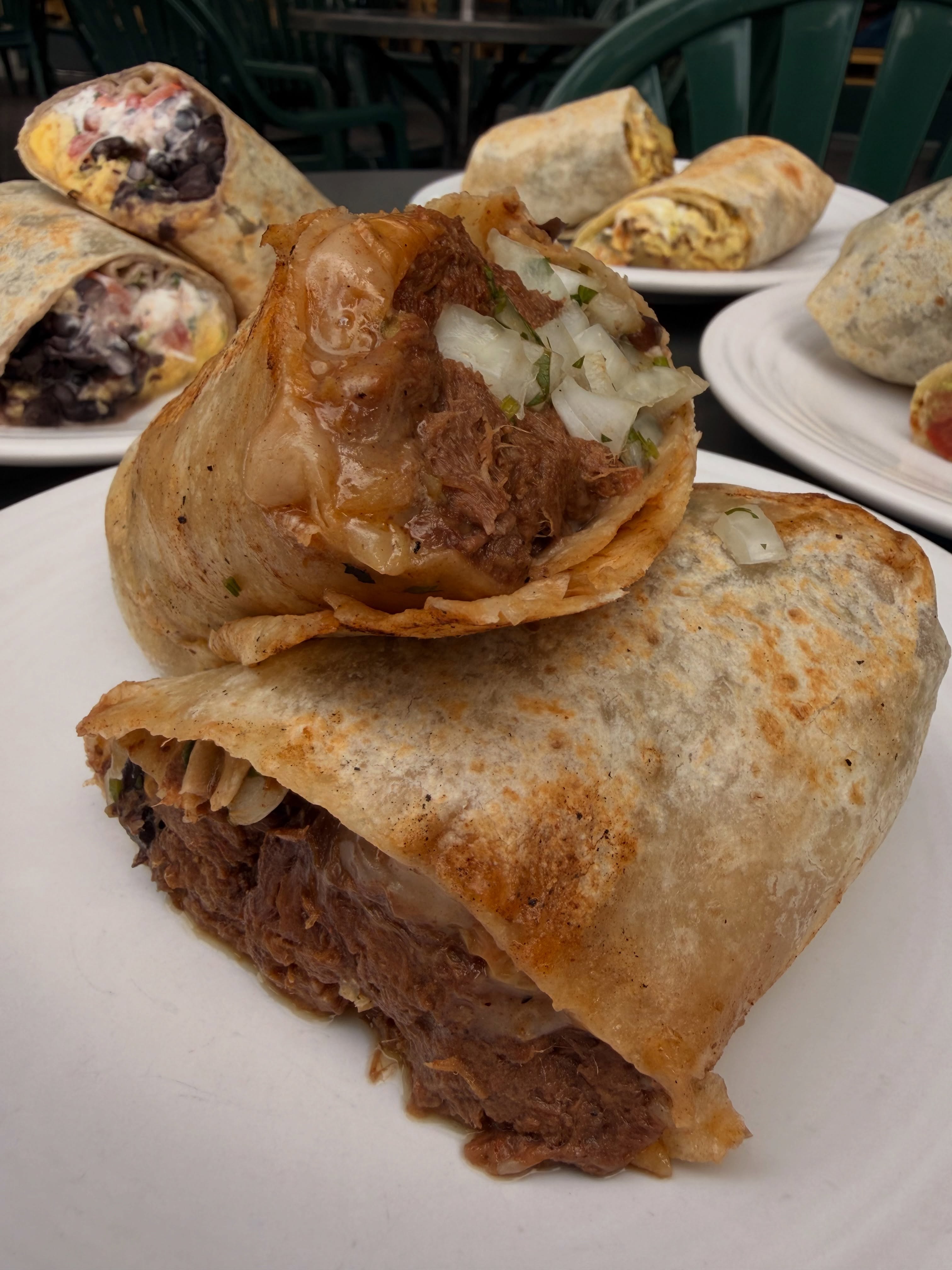 Carne asada and breakfast burritos sliced open on a plate